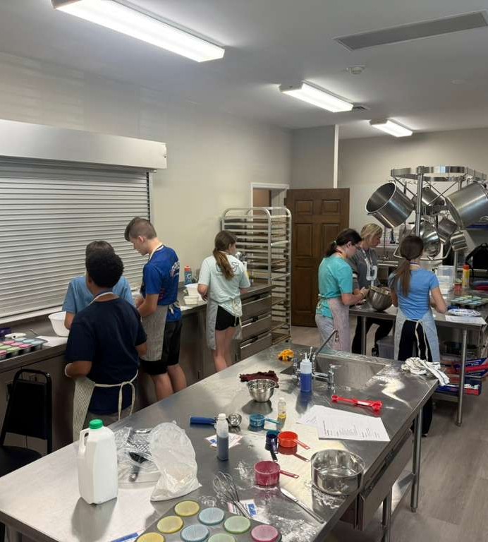 The Crumbs & Crowns founding cohort working together in the studio kitchen
